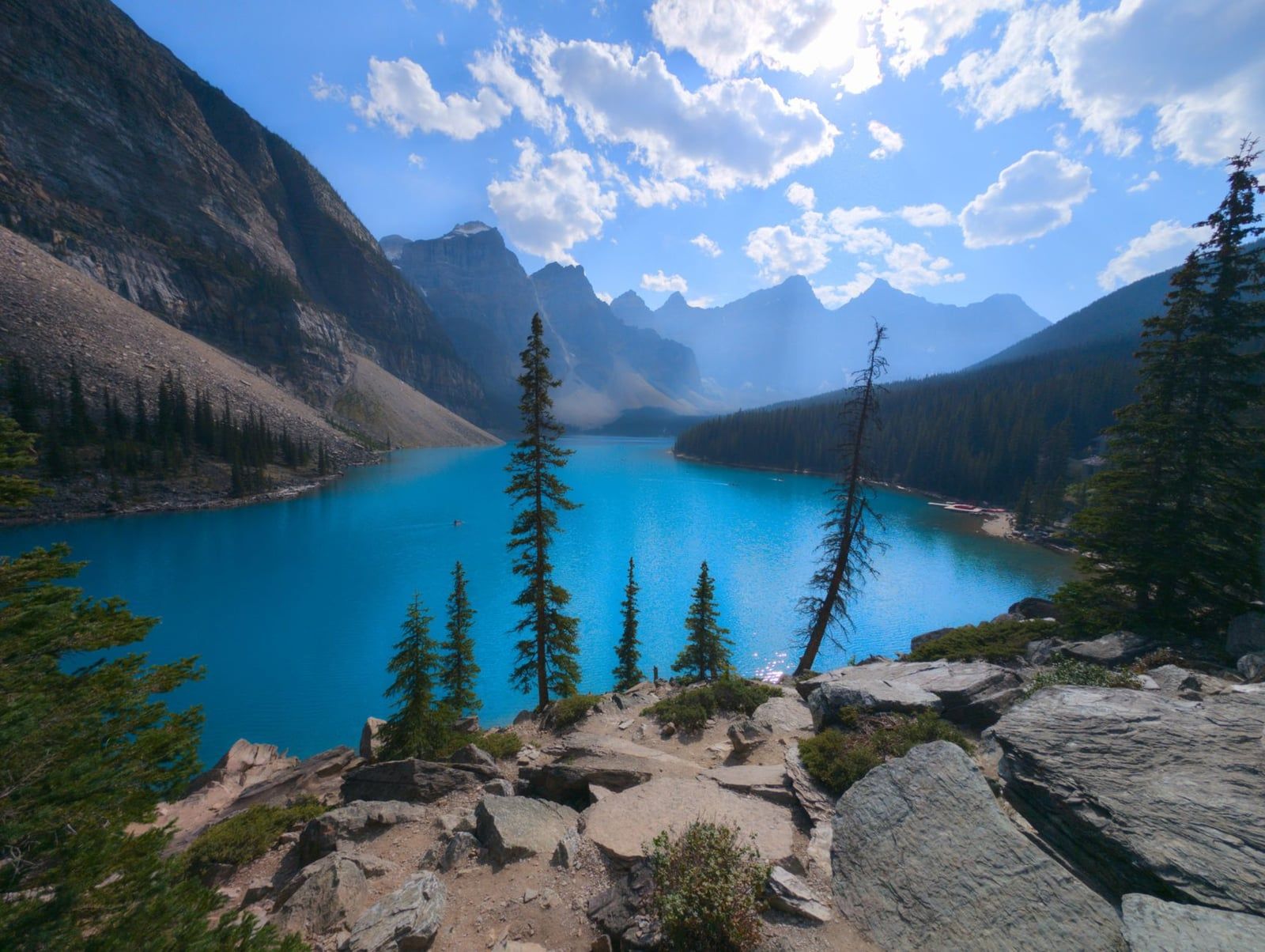 Les eaux turquoise éclatantes du lac Moraine s'étendent vers la vallée des Dix Pics sous un ciel bleu dans le parc national de Banff.