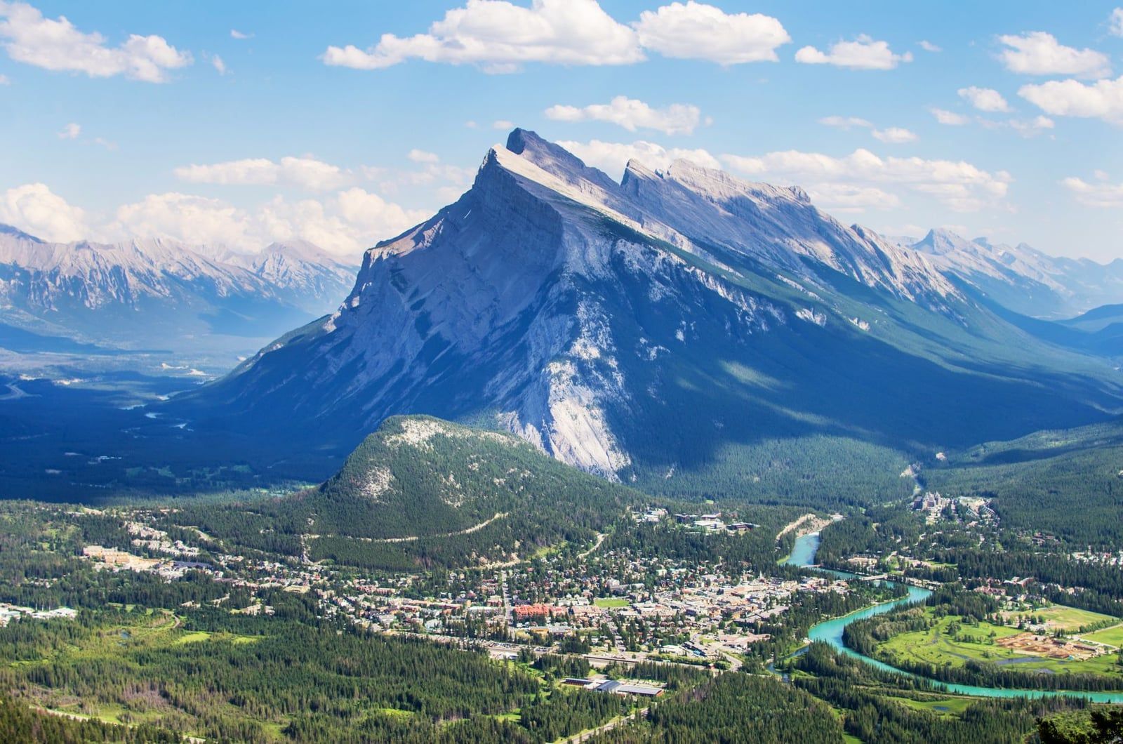 Mount Rundle rises above the Banff townsite and the turquoise Bow River in Banff National Park.